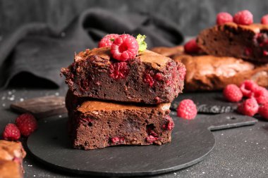 Siyah masanın üzerinde ahududulu çikolatalı browni var.