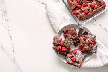 Beyaz arka planda ahudududulu çikolatalı brownie ile tabak ve pişirme tabağı.