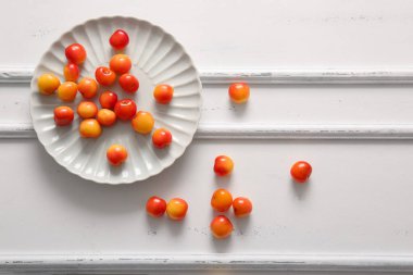 Beyaz masada tatlı sarı kirazlı bir tabak.