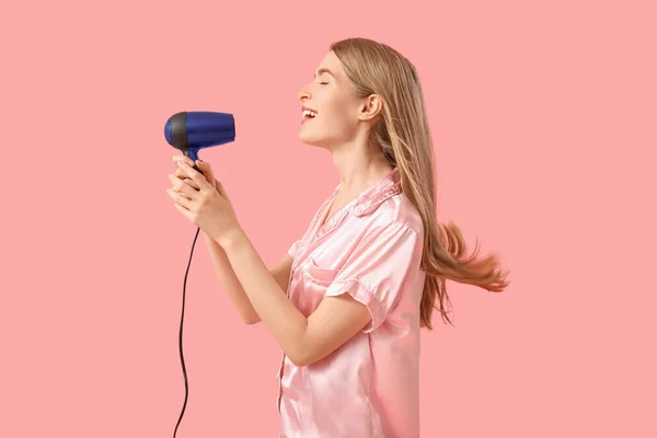 Young Blonde Woman Pajamas Hair Dryer Pink Background — Stock Photo, Image