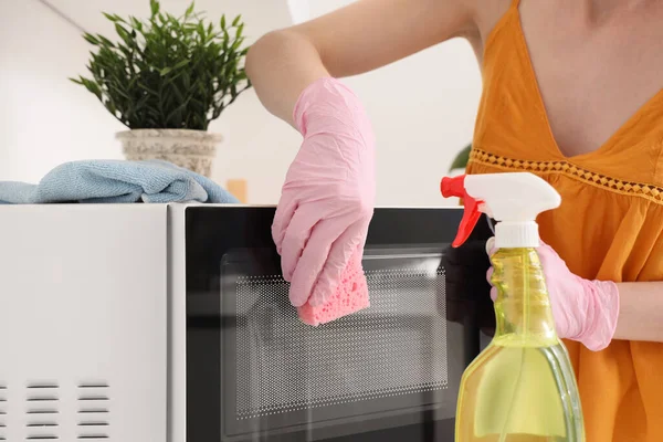 Kobieta Sprzątająca Kuchenkę Mikrofalową Gąbką Kuchni Zbliżenie — Zdjęcie stockowe