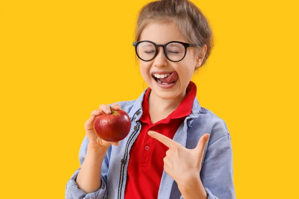 Mała Dziewczynka Wskazując Jabłko Żółtym Tle — Zdjęcie stockowe