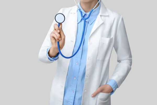 Kobieta Białym Płaszczu Stetoskopem Szarym Tle — Zdjęcie stockowe