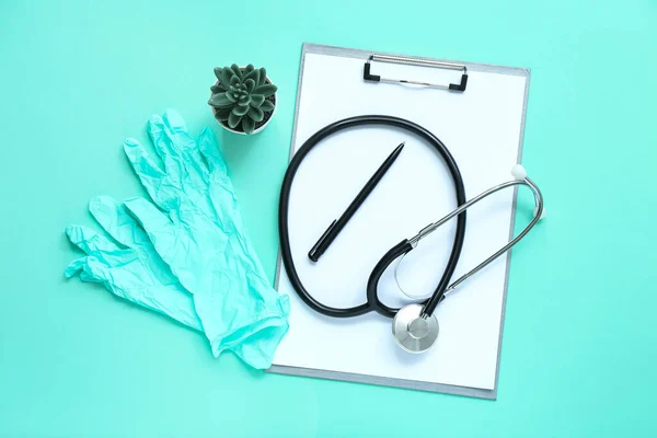 Stethoskop Klemmbrett Medizinische Handschuhe Stift Und Zimmerpflanze Auf Türkisfarbenem Hintergrund — Stockfoto