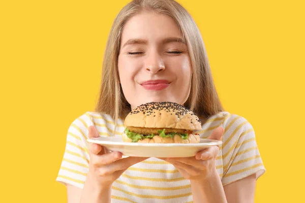 Young Woman Tasty Burger Yellow Background Closeup — Stock Photo, Image