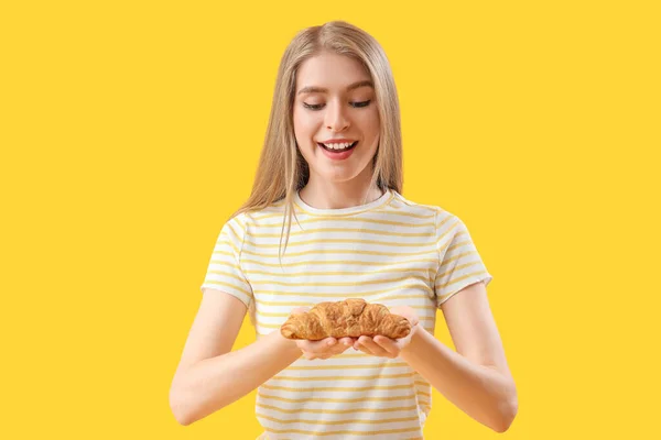 Mujer Joven Con Sabroso Croissant Sobre Fondo Amarillo —  Fotos de Stock