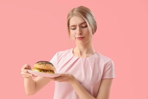 Junge Frau Mit Leckerem Burger Auf Rosa Hintergrund — Stockfoto