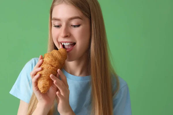 Junge Frau Isst Leckeres Croissant Auf Grünem Hintergrund Nahaufnahme — Stockfoto