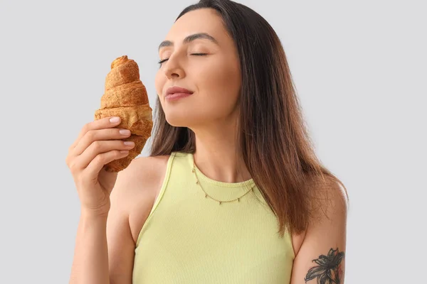 Jeune Femme Avec Croissant Savoureux Sur Fond Clair Gros Plan — Photo