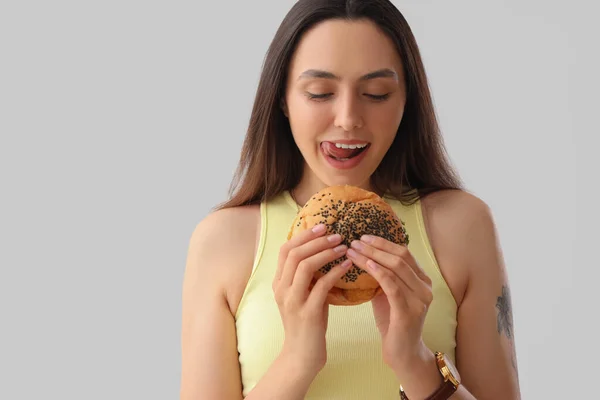 Młoda Kobieta Smacznym Burgerem Jasnym Tle — Zdjęcie stockowe