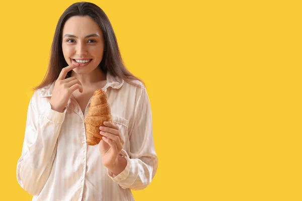 Giovane Donna Pigiama Con Gustoso Croissant Sfondo Giallo — Foto Stock