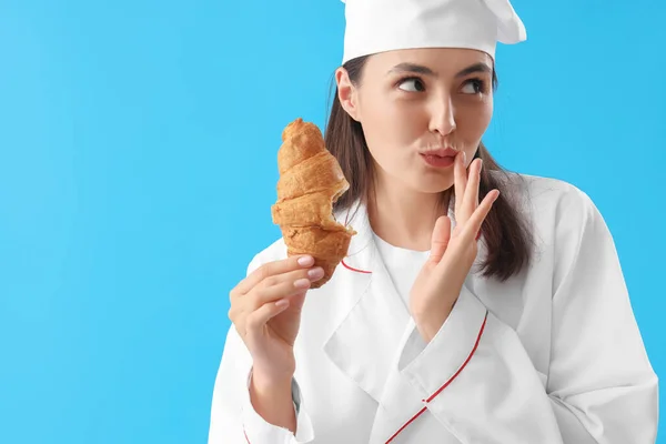 Chef Feminino Comer Croissant Saboroso Fundo Azul — Fotografia de Stock