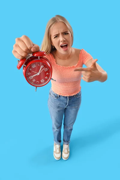 Stresli Genç Bir Kadın Mavi Arka Plandaki Çalar Saati Işaret — Stok fotoğraf