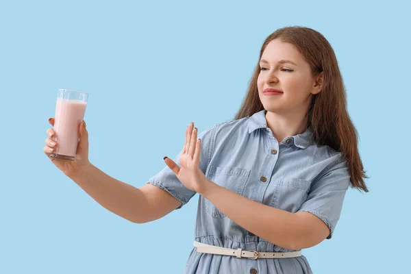 Niezadowolona Młoda Kobieta Odrzucająca Jogurt Niebieskim Tle — Zdjęcie stockowe