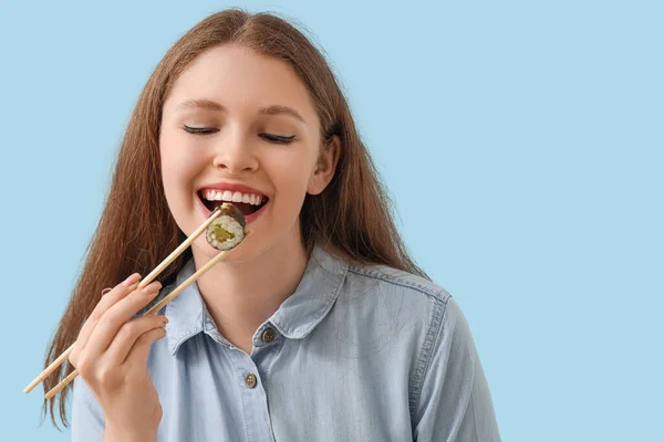 Mujer Joven Comiendo Sabroso Rollo Sushi Sobre Fondo Azul Primer — Foto de Stock
