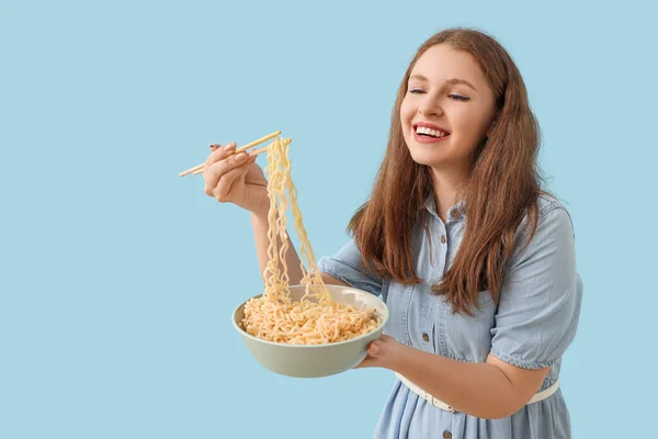 青い背景で中華麺を食べる若い女性 — ストック写真