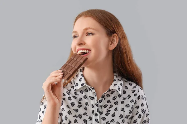 Young Woman Eating Tasty Chocolate Grey Background Closeup — Stock Photo, Image
