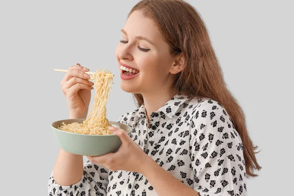 Young Woman Eating Tasty Chinese Noodles Grey Background Closeup — Stock Photo, Image