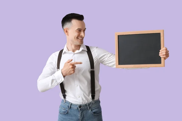 男教师指着紫丁香背景的黑板 — 图库照片