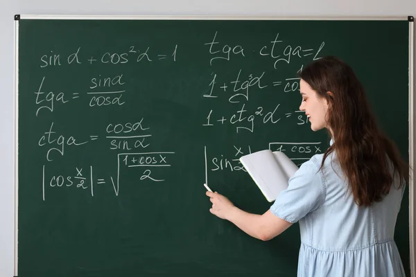 在课堂黑板上写作的女数学教师 — 图库照片