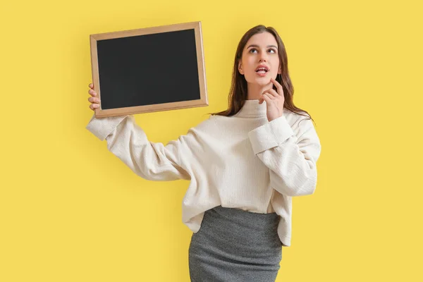 Nachdenkliche Lehrerin Mit Kreide Auf Gelbem Hintergrund — Stockfoto