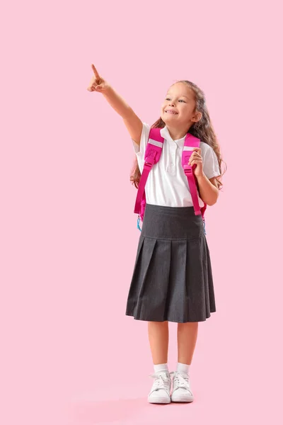 Klein Schoolmeisje Met Rugzak Wijzend Iets Roze Achtergrond — Stockfoto