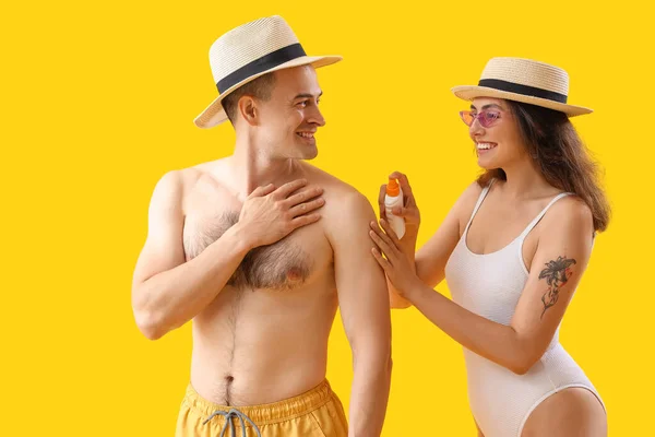 Junges Paar Cremt Sonnencreme Auf Gelbem Hintergrund Ein — Stockfoto