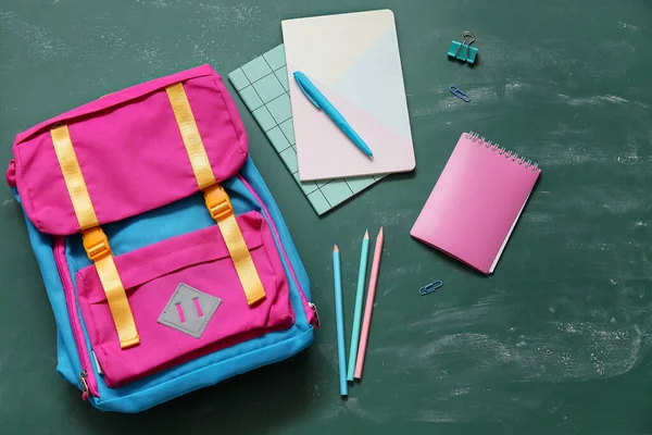 色彩斑斓的学校背包 带有绿色背景的笔记本 钢笔和铅笔 — 图库照片