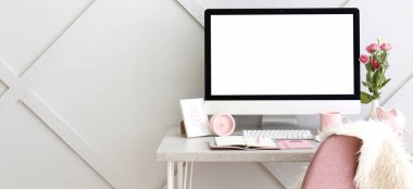 Gri duvarın yanında modern bilgisayarlı şık bir iş yeri. Tasarım için pankart