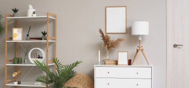 Boş çerçeveleri, çekmeceleri ve rafları olan modern bir oda. Tasarım için pankart