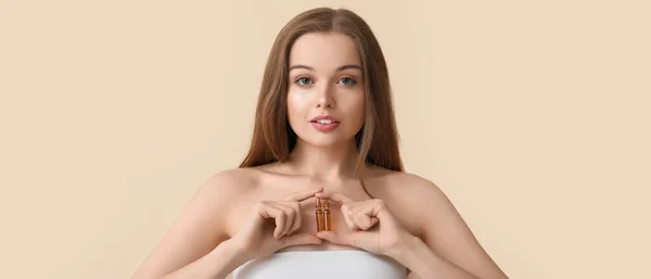 ベージュの背景にアンプルを持つ美しい若い女性 化粧品の概念 — ストック写真
