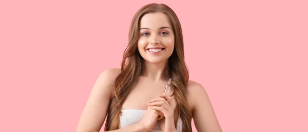 ピンクの背景にアンプルを持つ美しい若い女性 化粧品の概念 — ストック写真