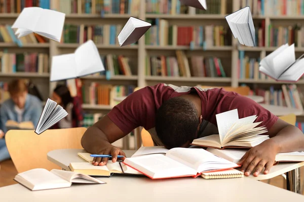 Втомлений Афроамериканський Студент Готується Іспиту Бібліотеці Літаючими Книгами — стокове фото