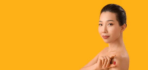 テキストのためのスペースと黄色の背景にアンプルを保持する美しいアジアの女性 化粧品の概念 — ストック写真