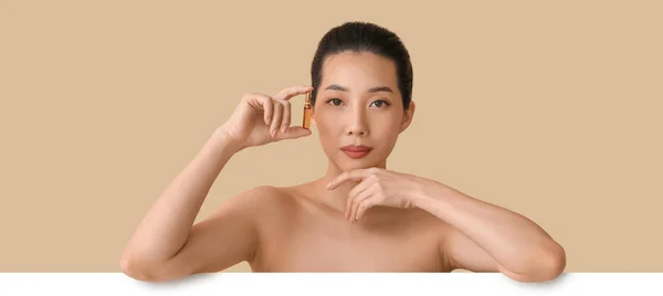 Piękna Azjatka Ampułką Beżowym Tle Koncepcja Kosmetyczna — Zdjęcie stockowe