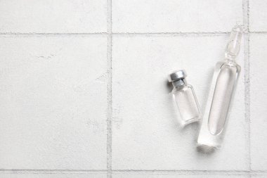 Beyaz karo zemin üzerinde tıbbi ampule