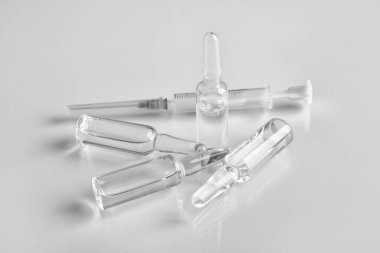 Işık arka planında şırıngası olan tıbbi ampule