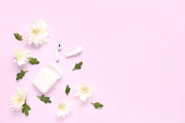 Renkli arka planda modern kulaklıklar, kasa ve kasımpatı çiçekleri ile kompozisyon