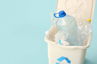 Açık mavi arka planda plastik olan çöp konteynırı. Geri dönüşüm kavramı
