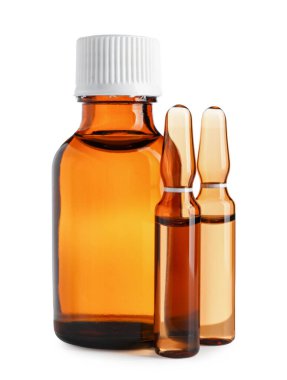 Beyaz arka planda ilaç bulunan ampuller ve şişeler.