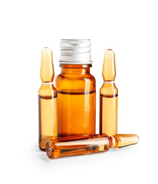 Beyaz arka planda ilaç bulunan ampuller ve şişeler.