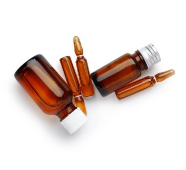 Beyaz arka planda ilaç bulunan ampuller ve şişeler