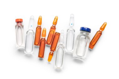 Beyaz arka planda ilaç bulunan tıbbi ampule ve şişeler.
