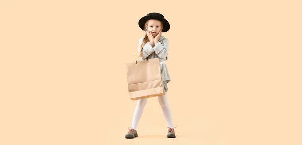 Έκπληκτο Κοριτσάκι Φθινοπωρινά Ρούχα Και Τσάντα Για Ψώνια Μπεζ Φόντο — Φωτογραφία Αρχείου
