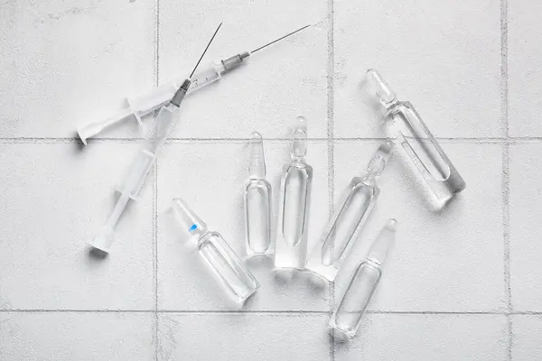 Ampollas Médicas Con Jeringas Sobre Fondo Baldosa Blanca — Foto de Stock
