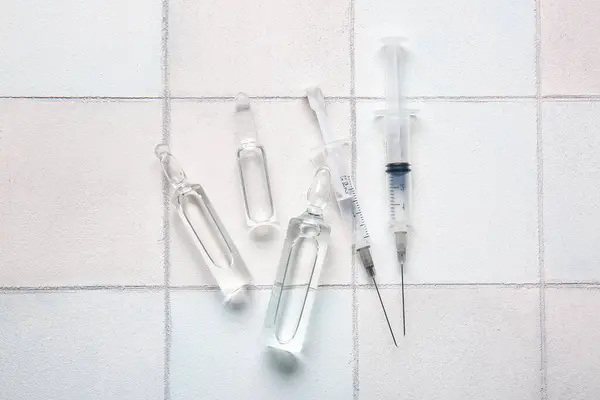 Medizinische Ampullen Mit Spritzen Auf Weißem Fliesenhintergrund — Stockfoto