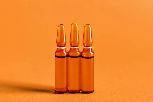 Glasampullen Auf Orangefarbenem Hintergrund — Stockfoto