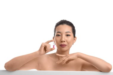 Beyaz arka planda ampulü olan güzel bir Asyalı kadın. Cilt bakımı kavramı