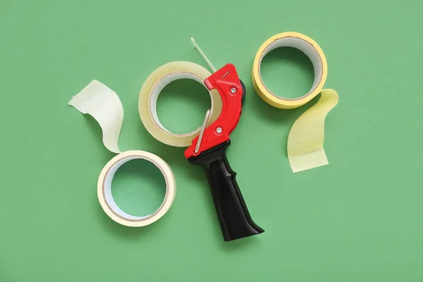 stock image Adhesive tape rolls and dispenser on green background