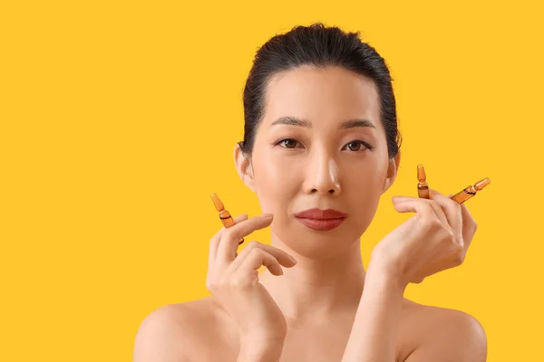 Mulher Asiática Bonita Com Ampolas Fundo Amarelo Conceito Cuidados Pele — Fotografia de Stock